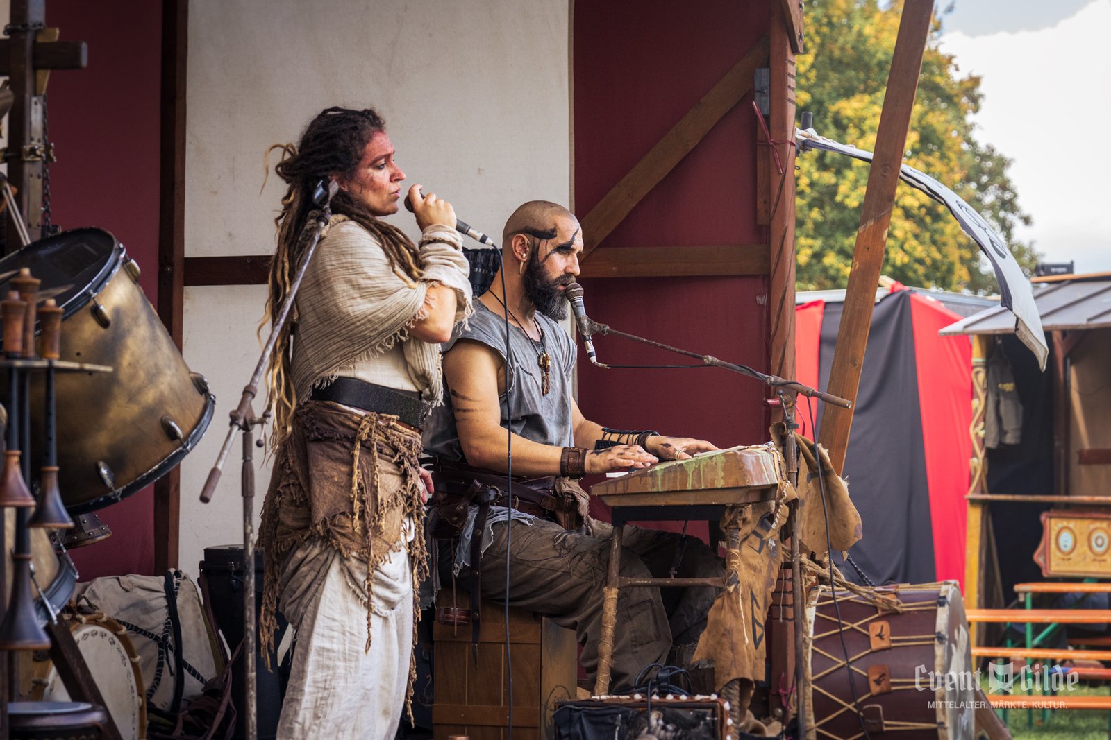Das Duo Dragol auf der Bühne beim Wikingerfest in Xanten, die Sängerin am Mikrofon, der Sänger mit Bemalung am Tasteninstrument